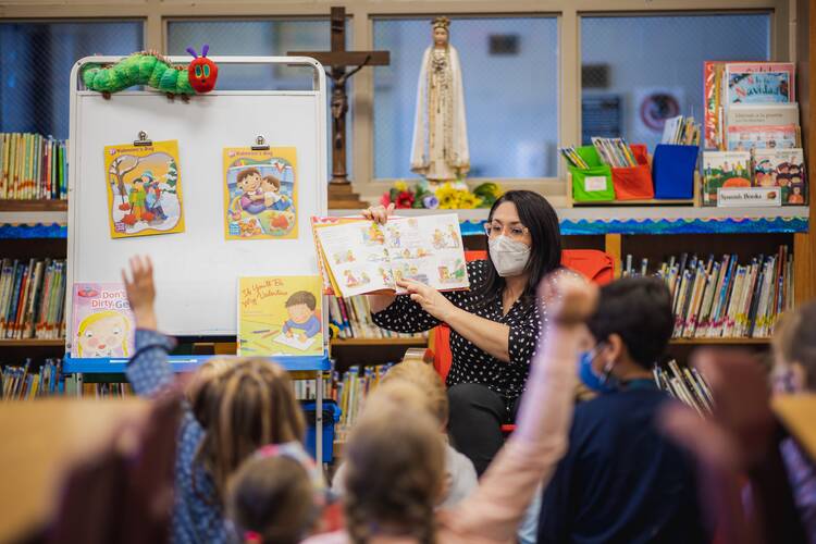 Suzanne Krumpelman, counselor at St. Joseph School in Fayetteville, Ark., reads to first graders about friendship Feb. 9, 2022, amid the COVID-19 pandemic. According to Catholic mental health professionals and diocesan officials, young people face considerable mental health challenges -- and the adults in their lives need to listen. (OSV News photo/CNS file, Travis McAfee, Arkansas Catholic)