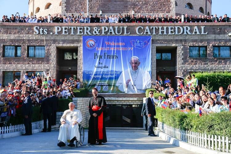 Pope Francis and Cardinal Giorgio Marengo, apostolic prefect of Ulaanbaatar, Mongolia, pose for a photo with the city's Catholics gathered outside Sts. Peter and Paul Cathedral in Ulaanbaatar, Mongolia, Sept. 2, 2023. (CNS photo/Lola Gomez)