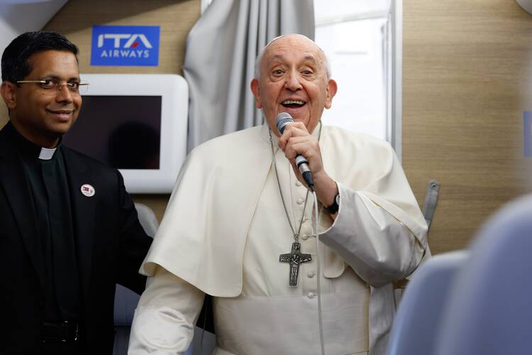 Pope Francis thanks journalists at the end of his inflight press conference on the way back to Rome from Ulaanbaatar, Mongolia, Sept. 4, 2023, after a four-day visit to the Asian country. To the left is Father George Koovakad, the organizer of papal trips. (CNS photo/Lola Gomez)