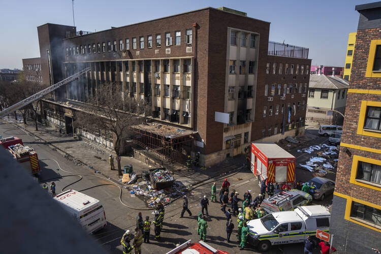 Medics stand by the covered bodies of victimes of a deadly blaze in downtown Johannesburg, South Africa, on Aug. 31. (AP Photo/Jerome Delay, File)
