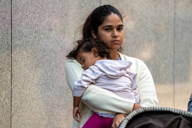 A migrant and her daughter wait for aid outside the offices of Catholic Charities in New York City, Aug. 16, 2022, after being transported via charter bus from Texas. (OSV News photo/David Delgado, Reuters)
