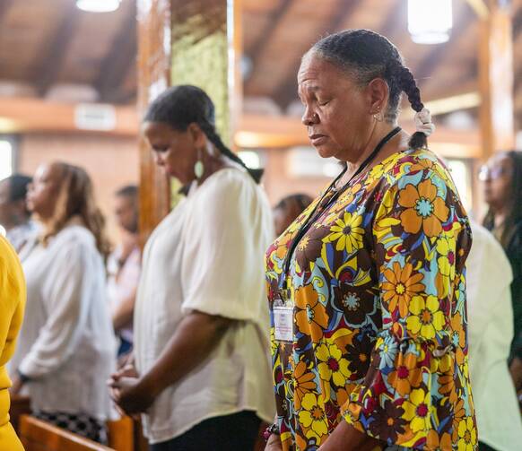 From left to right, family members Bernadette Semple (in the background), Toni Ann Semple and Denise Semple pray during Mass Sept. 3, 2023, at St. Peter Claver Church in St. Inigoes, Md. The Mass closed the Southern Maryland GU272 – Jesuit Enslaved Descendant Gathering Aug. 31-Sept. 3. (OSV News photo/ Mihoko Owada, Catholic Standard)