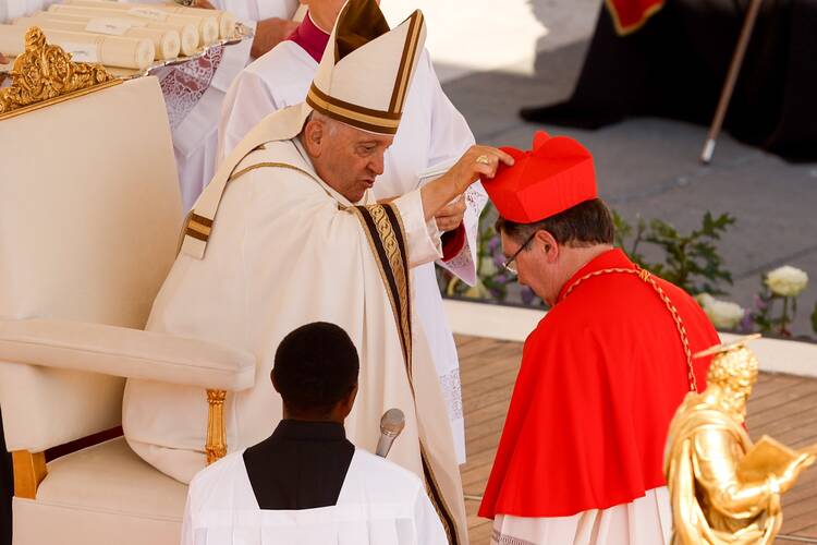 Pope Francis places a red biretta on the head of new Cardinal Christophe Pierre, nuncio to the United States, during a consistory for the creation of 21 new cardinals in St. Peter's Square at the Vatican Sept. 30, 2023. (CNS photo/Lola Gomez)