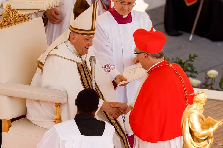 Pope Francis talks with new Cardinal Pierbattista Pizzaballa, Latin patriarch of Jerusalem, after presenting the red biretta to him during a consistory for the creation of 21 new cardinals in St. Peter's Square at the Vatican Sept. 30, 2023. (CNS photo/Lola Gomez)