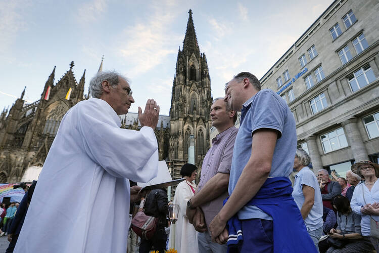 Same-sex couples take part in a public blessing ceremony in front of the Cologne Cathedral in Cologne, Germany, Wednesday, Sept. 20, 2023. Several Catholic priests held a ceremony blessing same-sex and also re-married couples outside Cologne Cathedral in a protest against the city's archbishop, Cardinal Rainer Maria Woelki. (AP Photo/Martin Meissner)