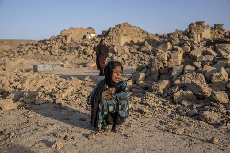 An Afghan girl weeps in front of her home, destroyed by the earthquake in Zenda Jan district in Herat province. Another strong earthquake shook western Afghanistan on Oct. 11 after an earlier one killed more than 2,000 people and flattened whole villages in Herat province in what was one of the most destructive quakes in the country's recent history. (AP Photo/Ebrahim Noroozi)