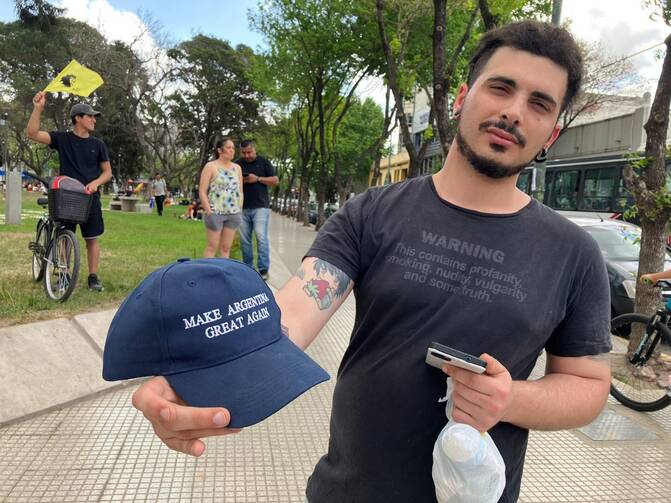 Matias Abate holds an Argentine version of a MAGA hat he wore to a rally for libertarian presidential candidate Javier Milei in suburban Buenos Aires. Abate, an unemployed metal worker, plans to vote for Milei as a protest against the political class. Photo by David Agren.