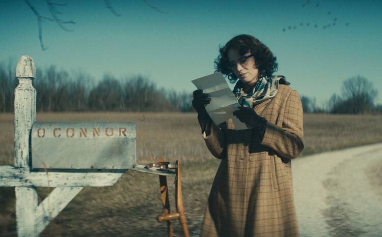 Maya Hawke pictured playing Flannery O’Connor opening a letter by a mailbox in the biopic ‘Wildcat’