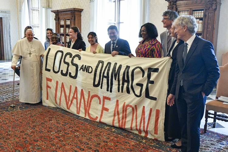 Pope Francis joins others in holding a banner during an audience at the Vatican June 5, 2023, with the organizers of the Green & Blue Festival. The banner calls for financing a "loss and damage" fund that was agreed upon at the COP27 U.N. climate conference in 2022. The fund would seek to provide financial assistance to nations most vulnerable and impacted by the effects of climate change. (CNS photo/Vatican Media)