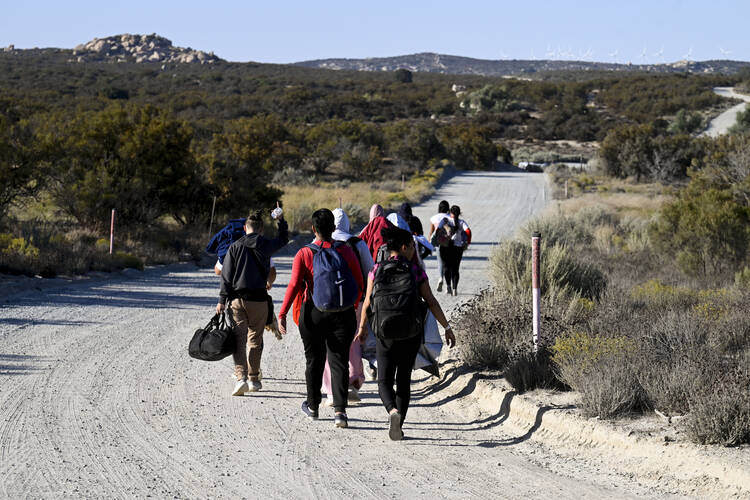 Asylum-seekers walk to a U.S. Border Patrol van after crossing the nearby border with Mexico on Sept. 26, 2023, near Jacumba Hot Springs, Calif. (AP Photo/Denis Poroy, File)
