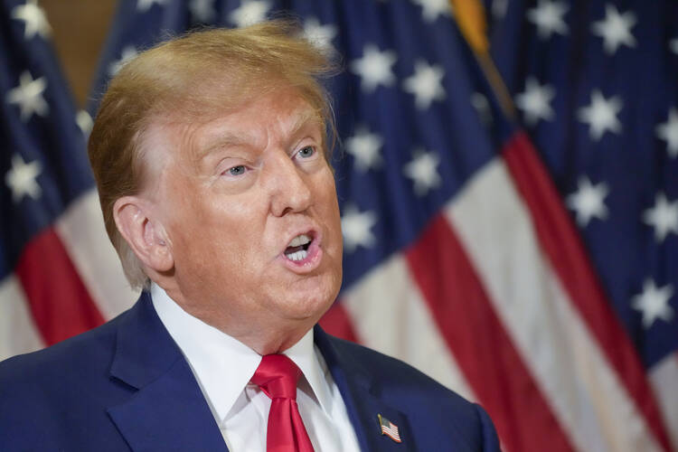 In addition to Colorado and Maine, officials in at least 10 other states may soon try to disqualify Mr. Trump, seen here speaking in front of a row of American flags. (AP Photo/Mary Altaffer, File)