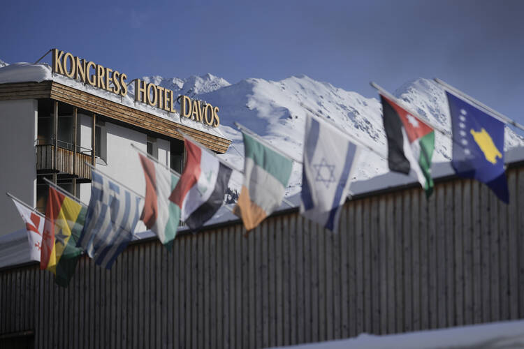 International flags wave on top of the Davos Congress Center where the World Economic Forum takes place in Davos, Switzerland, Monday, Jan. 15, 2024. The annual meeting of the World Economic Forum is taking place in Davos from Jan. 15 until Jan. 19, 2024.(AP Photo/Markus Schreiber)