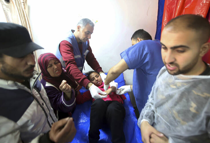 Palestinian medics treat a girl wounded in the Israeli bombardment of a building at a vocational training center that displaced people use as a shelter in Khan Younis, southern Gaza Strip, on Jan. 24, 2024. (AP Photo/Ramez Habboub)
