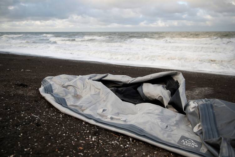 A damaged inflatable dinghy is seen on Loon Beach in Dunkirk, France, on Nov. 25, 2021, the day after 27 migrants died when their dinghy deflated as they attempted to cross the English Channel. (CNS photo/Johanna Geron, Reuters)