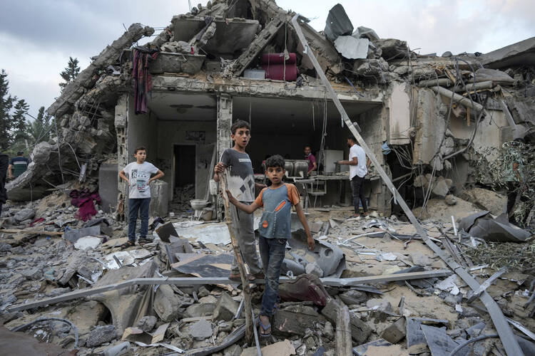 Children gather over the destruction after an Israeli airstrike in Deir al Balah, Gaza Strip, on April 30, 2024. (AP Photo/Abdel Kareem Hana)