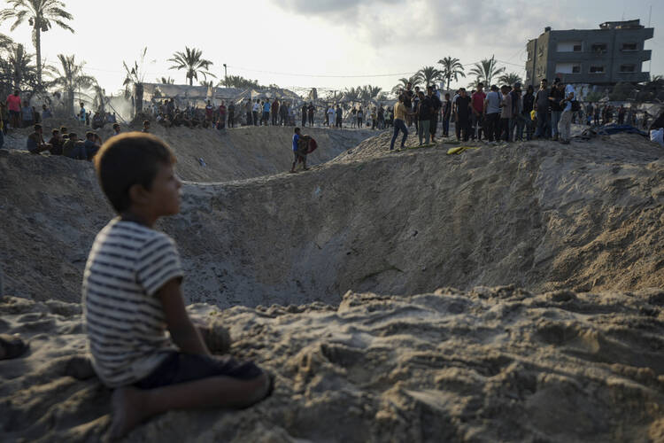 A child looks at the aftermath of an Israeli airstrike in a tent camp housing Palestinians displaced by the war in Muwasi, Gaza Strip, on Sept. 10, 2024. (AP Photo/Abdel Kareem Hana, file)