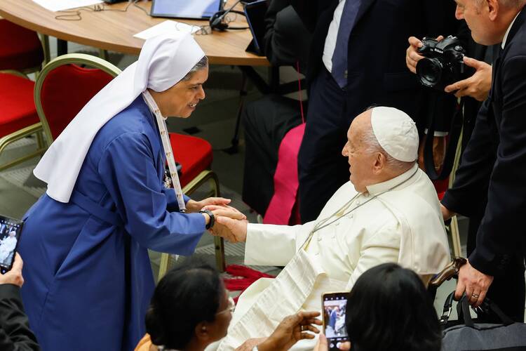 Pope Francis greets a religious woman before the start of the opening working session of the Synod of Bishops