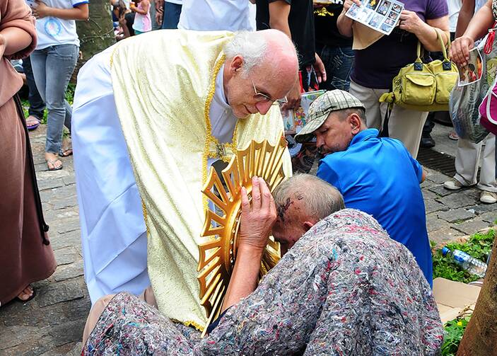 Digital evangelizer and advocate for homeless people, the Rev. Julio Lancellotti blesses a homeless man in Sao Paulo. (CNS photo/Luciney Martins, courtesy O Sao Paulo)
