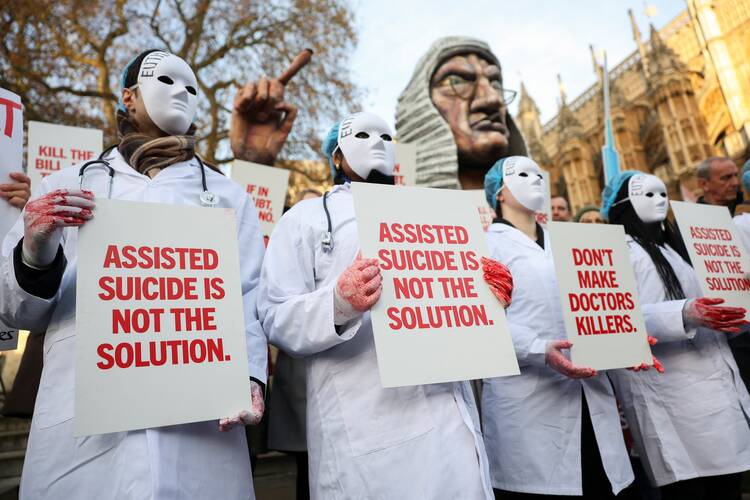 Protestors stand outside Parliament as British lawmakers debate an assisted dying law in London on Nov. 29, 2024. (OSV News photo/Mina Kim, Reuters)