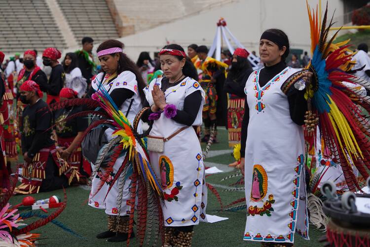 People dressed in Indigenous costumes pray during the 91st procession and Mass honoring Our Lady of Guadalupe and St. Juan Diego in Los Angeles on Dec. 4, 2022.(CNS photo/courtesy Archdiocese of Los Angeles)