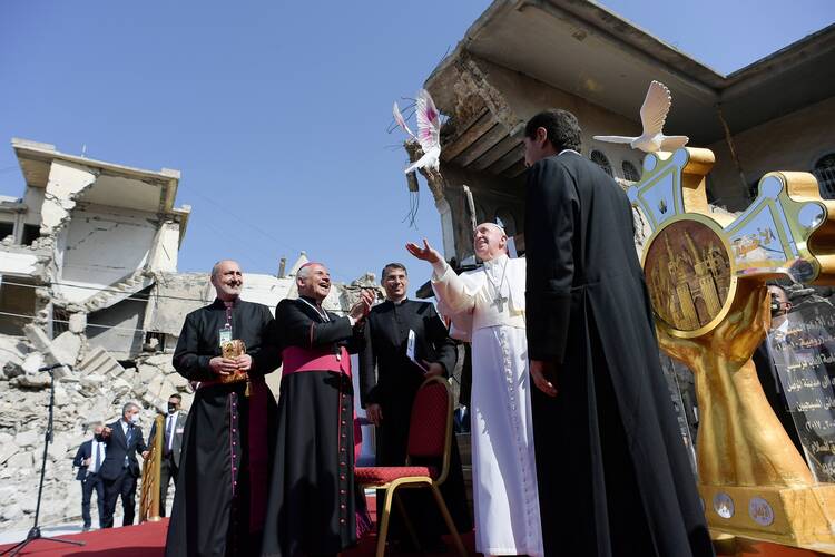Pope Francis releases a white dove during a memorial prayer for the victims of the war at Hosh al-Bieaa (church square) in Mosul, Iraq, in this March 7, 2021, file photo. Being against war demands courageous craftsmanship, the pope wrote in the forward to a new book. (CNS photo/Vatican Media)