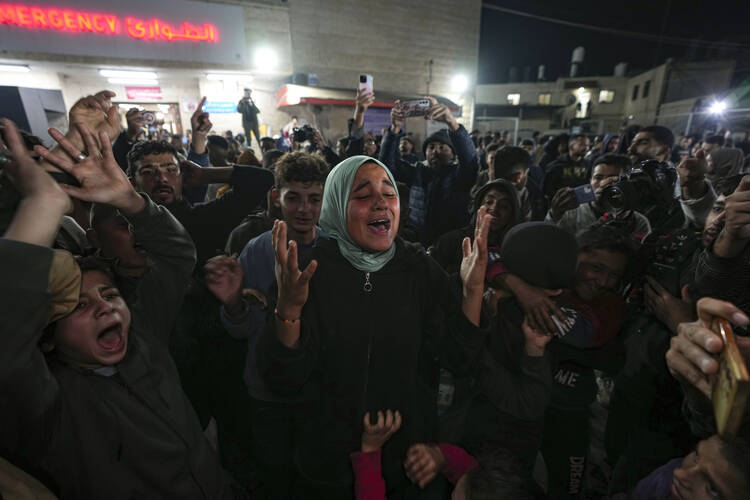 Palestinians celebrate the announcement of a ceasefire deal between Hamas and Israel in Deir al-Balah, central Gaza Strip, Wednesday, Jan. 15, 2025. (AP Photo/Abdel Kareem Hana)