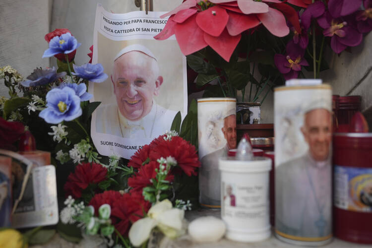 Candles and a photo of Pope Francis are seen in front of the Agostino Gemelli Polyclinic, in Rome, Saturday, Feb. 22, 2025, where the Pontiff is hospitalized since Friday, Feb. 14. (AP Photo/Alessandra Tarantino)