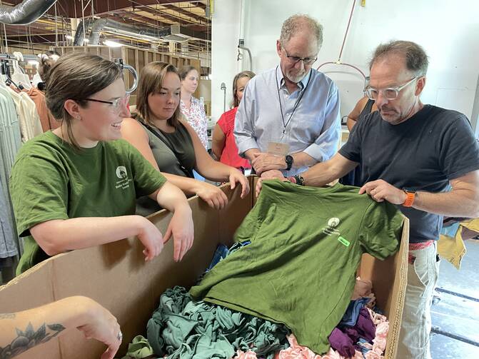 At a CEPA immersion tour in North Carolina in 2023, Sarah Richards (left), from the University of Dayton, listens in as Eric Henry (far right), president of TS Designs, describes how an ethical supply chain delivers college swag to Dayton students.