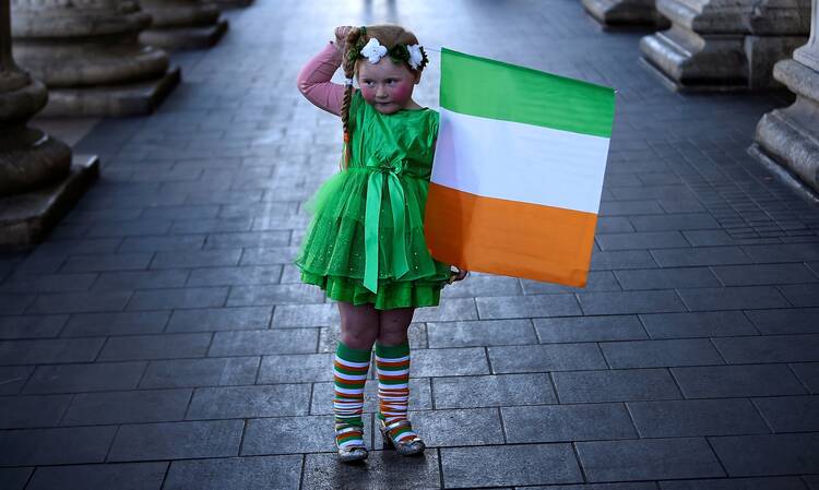 A girl who was part of a procession holds the flag of Ireland on St. Patrick's Day in Dublin March 17, 2021, during the COVID-19 pandemic. (CNS photo/Clodagh Kilcoyne, Reuters)