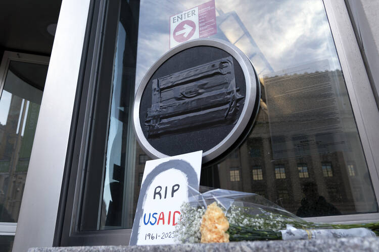 Flowers and a sign reading "RIP USAID" are seen outside the headquarters of the U.S. Agency for International Development on Feb. 7 in Washington. (AP Photo/Jose Luis Magana, file)