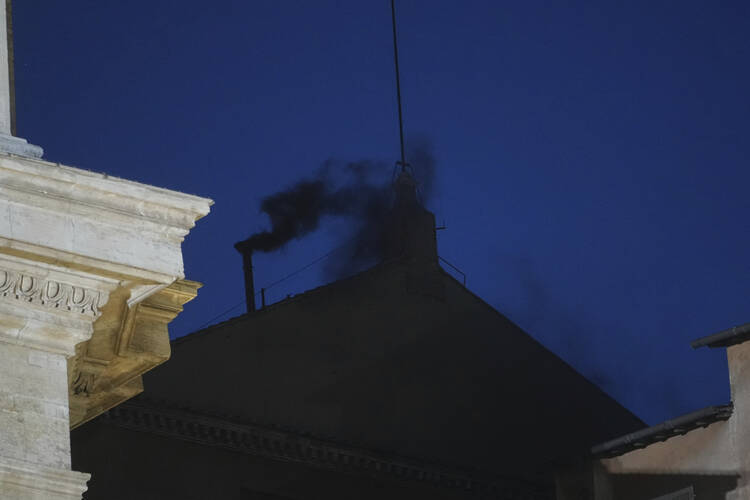 black smoke emerges from the sistine chapel on the first day of the conclave, the sky is a dark blue at 9 pm Rome time