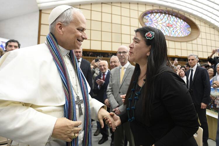 Paola Ugaz, a Peruvian journalist who helped expose the abuse committed by leaders of the Sodalitium Christianae Vitae, gives Pope Leo XIV a stole made of alpaca wool, during the pope's meeting with members of the media May 12, 2025, in the Paul VI Audience Hall at the Vatican. (CNS photo/Vatican Media)