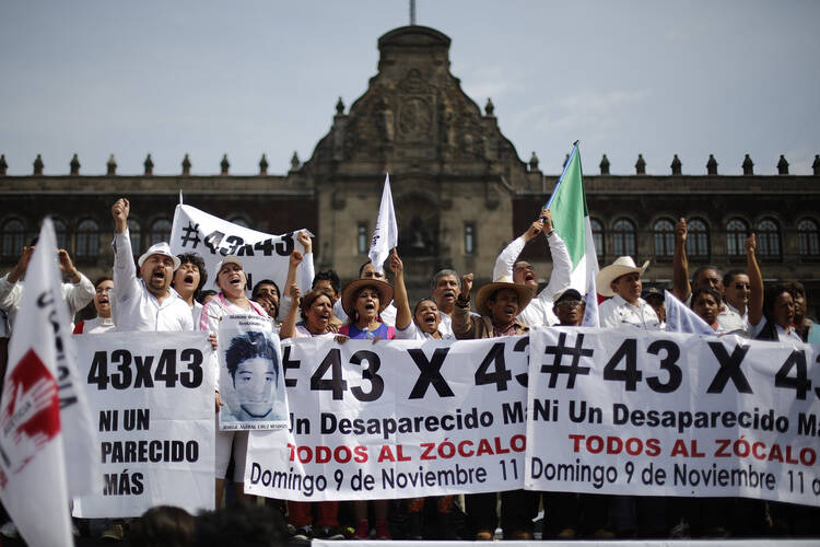 People carry banners and flags in Mexico City Nov. 9, as they take part in a protest to demand more information about the 43 missing students. They marched 112 miles from Iguala. (CNS photo/Tomas Bravo, Reuters)