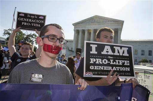 Activists demonstrate in front of the Supreme Court in Washington, Monday, June 27, 2016, as the justices close out the term with decisions on abortion, guns, and public corruption are expected. (AP Photo/J. Scott Applewhite)
