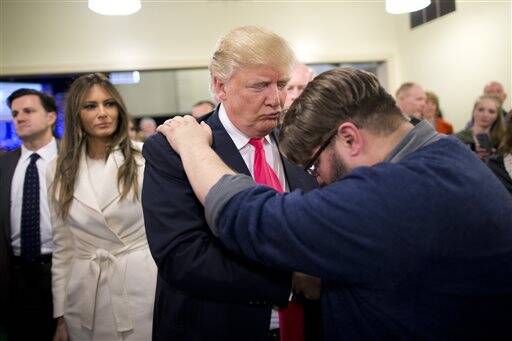 Evangelical pastor Joshua Nink, right, prays for Republican presidential candidate Donald Trump, as wife, Melania, left, watches after a Sunday service at First Christian Church, in Council Bluffs, Iowa. (AP Photo/Jae C. Hong, File)
