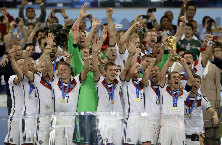 In this July 13, 2014 photo, Germany's Philipp Lahm holds up the World Cup trophy as the team celebrates their 1-0 victor over Argentina after the World Cup final soccer match between Germany and Argentina in Rio de Janeiro, Brazil. (AP Photo/Natacha Pisarenko)