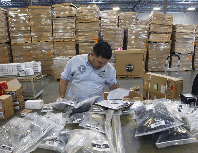 Claudio Montes checks a shipping manifest for U.S. manufactured parts heading to assembly plants in Mexico at Freight Dispatch Service Agency LTD in Pharr, Texas in June 2017. The freight service ships parts between the U.S. and Mexico that pass through the border freely due to the North American Free Trade Agreement. (Nathan Lambrecht/The Monitor via AP, File)