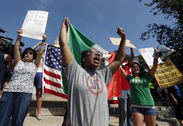 Counterprotesters hold signs and chant at the Statehouse before a planned "Free Speech" rally by conservative organizers begin on the adjacent Boston Common, Saturday, Aug. 19, 2017, in Boston. (AP Photo/Michael Dwyer)