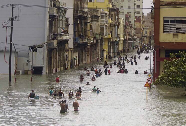 People move through flooded streets in Havana after the passage of Hurricane Irma, in Cuba, Sunday, Sept. 10, 2017. (AP Photo/Ramon Espinosa)