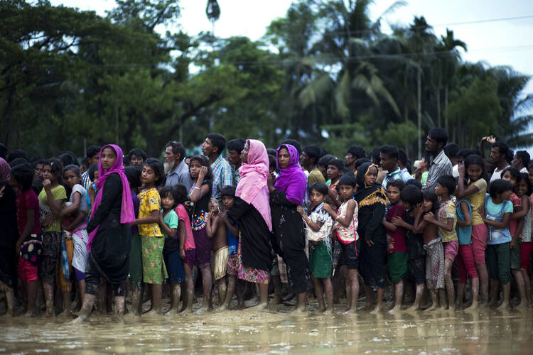 Rohingya Muslims, who crossed over recently from Myanmar into Bangladesh, stand in a queue to receive food being distributed near Balukhali refugee camp in Cox's Bazar, Bangladesh, on Tuesday, Sept. 19, 2017. More than 500,000 Rohingya Muslims have fled to neighboring Bangladesh in the past year, most of them in the last three weeks, after security forces and allied mobs retaliated to a series of attacks by Muslim militants last month by burning down thousands of Rohingya homes in the predominantly Buddhist