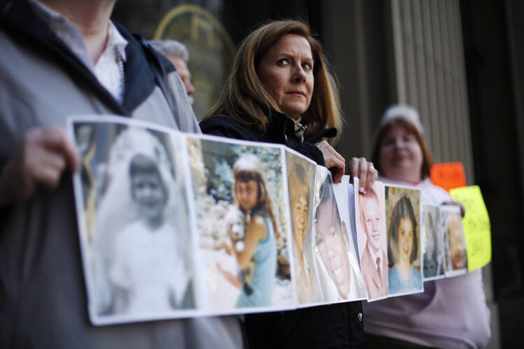 In this March 29, 2011, file photo, Barbara Blaine, President of Survivors Network of those Abused by Priests (SNAP), displays childhood photographs of adults who say they were sexually abused, during a news conference in Philadelphia. Barbara Blaine, the founder and former president of the Survivors Network of those Abused by Priests, has died. The organization known as SNAP announced on its Facebook page that Blaine died Sunday, Sept. 24, 2017, following a recent cardiac event. She was 61. (AP Photo/Matt 