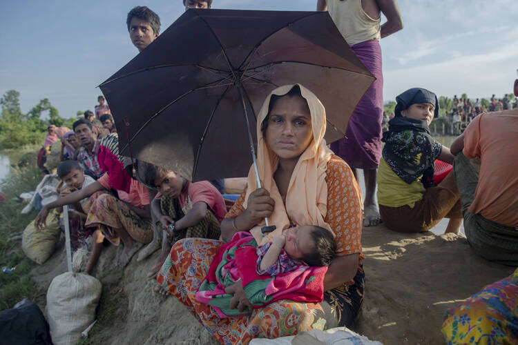 A newly arrived Rohingya Muslim woman Anjuna Khatoon, 23, holds her 5-day-old baby girl who she gave birth to while making the journey to cross the border from Myanmar to Bangladesh, at Palong Khali, Bangladesh, Tuesday, Oct. 17, 2017. Thousands more Rohingya Muslims are fleeing large-scale violence and persecution in Myanmar and crossing into Bangladesh, where more than half a million others are already living in squalid and overcrowded camps, according to witnesses and a drone video shot by the U.N. offic