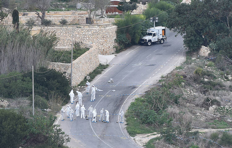 Forensic police work on the main road in Bidnija, Malta, which leads to Daphne Caruana Galizias house, looking for evidence on the blast that killed the journalist as she was leaving her home, Thursday, Oct. 19, 2017. Caruana Galizia, a harsh critic of Maltese Premier Joseph Muscat, and who reported extensively on corruption on Malta, was killed by a car bomb on Monday. (AP Photo/Rene Rossignaud)