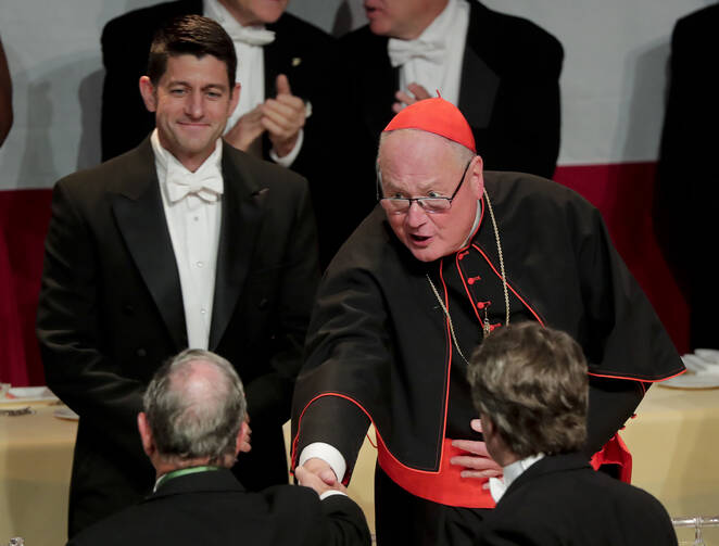 Cardinal Timothy Dolan, right, shakes hands with former New York City Mayor Michael Bloomberg as Speaker of the House Paul Ryan, left, looks on during the 72nd Annual Alfred E. Smith Memorial Foundation dinner Thursday, Oct. 19, 2017, in New York. (AP Photo/Julie Jacobson)
