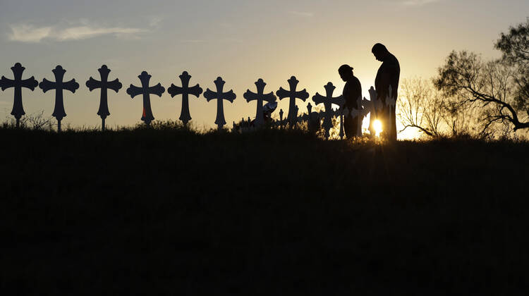 Isaac Hernandez and his wife Crystal visit a line of crosses before a vigil for the victims of the First Baptist Church shooting, Monday, Nov. 6, 2017, in Sutherland Springs, Texas. (AP Photo/David J. Phillip)