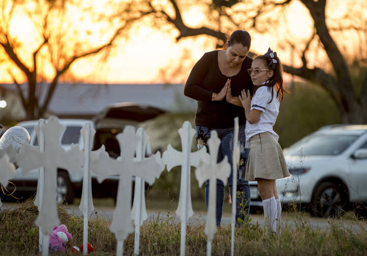 Meredith Cooper, of San Antonio, Tex., and her 8-year-old daughter, Heather, visit a memorial of 26 metal crosses near First Baptist Church in Sutherland Springs, Tex., on Nov. 6. (Jay Janner/Austin American-Statesman via AP)