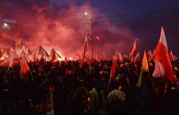 Demonstrators burn flares and wave Polish flags during the annual march to commemorate Poland's National Independence Day in Warsaw, Poland, Saturday, Nov. 11, 2017. Thousands of nationalists marched in Warsaw on Poland’s Independence Day holiday, taking part in an event that was organized by far-right groups. (AP Photo/Czarek Sokolowski)