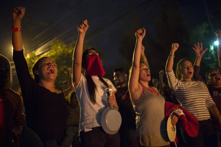 Anti-government protestors shout slogans during a government imposed dawn-to-dusk curfew in Tegucigalpa, Honduras, on Dec. 3. (AP Photo/Rodrigo Abd)