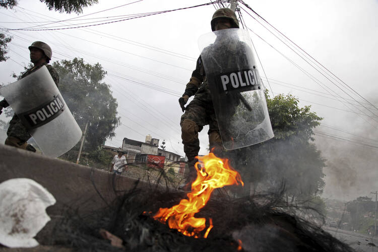 Military police clear a barricade set up overnight by protestors supporting opposition presidential candidate Salvador Nasralla in Tegucigalpa, Honduras, Monday Dec. 18, 2017. (AP Photo/Fernando Antonio)