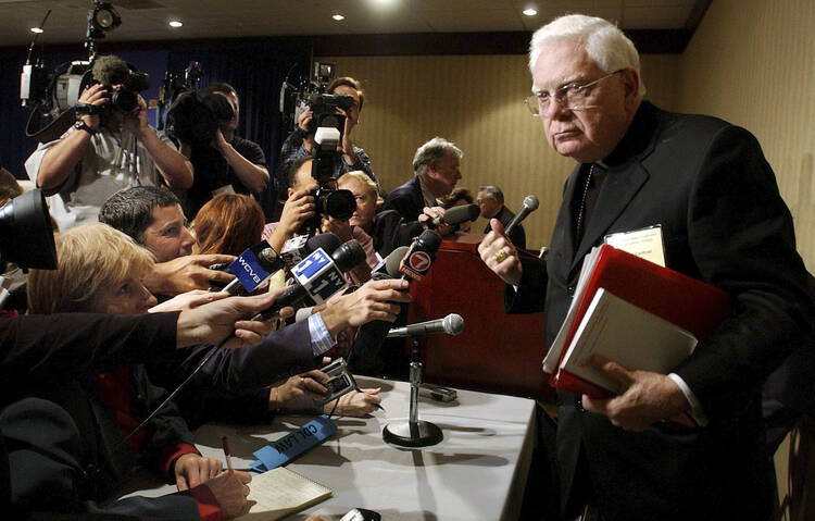 In this Tuesday, Nov. 12, 2002 file photo, Cardinal Bernard Law, right, departs a news conference during the second day of the U.S. Conference of Catholic Bishops annual meeting in Washington (AP Photo/Ken Lambert, File).